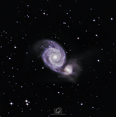 An incredible image of the Whirlpool Galaxy, a mesmerizing spiral galaxy located in the constellation of Ursa Major. The galaxy's distinct spiral arms, adorned with countless stars and dust lanes, create a whirlpool-like pattern. This captivating cosmic marvel shines with a blend of blue and gold hues against the backdrop of deep space, showcasing the immense beauty and cosmic dance of celestial bodies within the vast universe.